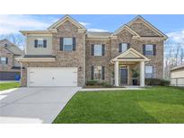 Charming two-story brick home with a well-manicured lawn, attached two car garage, and covered front porch at 4826 Ralin Ct, Atlanta, GA 30331