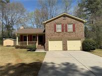 Charming two-story brick home featuring an attached two-car garage and a well-maintained front yard at 2917 High Brook Se Way, Conyers, GA 30094