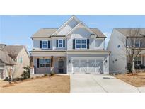 Charming two-story home with a well-manicured lawn and a two-car garage at 162 Spaulding Ln, Woodstock, GA 30188