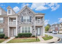 Charming townhome featuring stone and siding, complemented by a well-manicured lawn at 7808 Rutgers Cir, Fairburn, GA 30213