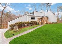 Inviting home featuring stone accents, lush green lawn, and a contemporary architectural design at 2125 Datona Sw Dr, Atlanta, GA 30331