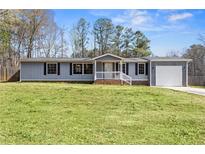 Charming one-story home with a well-maintained lawn and attached garage, perfect for suburban living at 1833 Lost Mountain Rd, Powder Springs, GA 30127