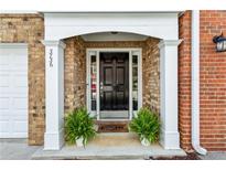 Charming brick home entrance features a black door with white trim and decorative plants at 3736 Chattahoochee Summit Se Dr # 20, Atlanta, GA 30339