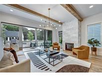 Bright living room boasts hardwood floors, modern light fixture, marble fireplace, and deck access at 2171 James Aly, Atlanta, GA 30345