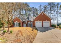Beautiful brick home with well-manicured lawn and a two-car garage provides great curb appeal at 500 Huntgate Rd, Woodstock, GA 30189