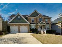 Charming two-story brick home with a two-car garage and well-manicured front lawn at 4001 Oak Field Dr, Loganville, GA 30052