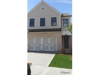 Two-story home with a light brick base, a front yard, a large door garage and neutral siding on the top half at 1071 Crest Mill Dr, Marietta, GA 30008