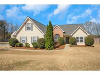 Charming home with manicured landscaping, complemented by a lush green lawn and inviting facade at 2450 Cordillo Ne Dr, Dacula, GA 30019