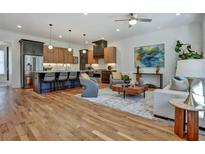 Open-concept living room featuring hardwood floors, modern lighting, kitchen island and stylish contemporary furniture at 2159 James Aly, Atlanta, GA 30345