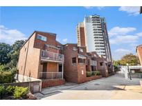 Brick townhome with balconies and a view of a high-rise building on a sunny day at 385 Ralph Mcgill Ne Blvd # D, Atlanta, GA 30312