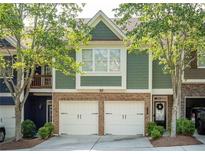 Charming townhome showcasing a brick facade, two-car garage, and verdant landscaping, creating a welcoming curb appeal at 2396 Meadow Falls Ln, Duluth, GA 30097