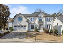 Charming two-story brick home with a well-manicured lawn and a two-car garage, painted in a stylish white color at 2890 Olde Town Park Dr, Norcross, GA 30071