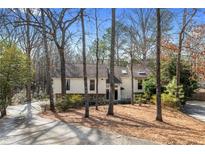 Charming home nestled among the trees with a stone accent and long driveway at 8498 Colony Club Dr, Alpharetta, GA 30022