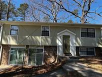 Charming split-level home featuring a stone facade, multiple windows, and a welcoming front entrance with steps at 4690 Big Valley Ct, Stone Mountain, GA 30083