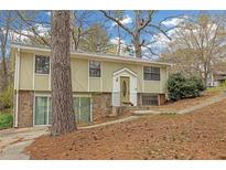 Split-level home with unique architectural details and a stone facade on the lower level at 4690 Big Valley Ct, Stone Mountain, GA 30083