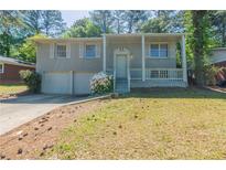 Charming split-level home with a welcoming front porch and a two-car garage at 1477 Patricia Dr, Morrow, GA 30260