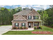 Beautiful two-story brick home featuring manicured lawn, complementing landscaping and inviting entrance at 104 Amelia Way, Ellenwood, GA 30294