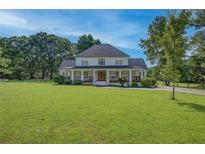 Charming two-story home with a large front yard and inviting covered porch at 4177 Sardis Church Rd, Buford, GA 30519