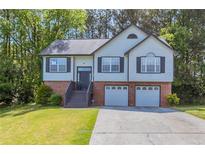 Charming two-story home features a two-car garage, landscaped front yard, and inviting entryway at 1202 W Briar Gate Ct, Riverdale, GA 30296