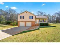 Charming two-story home featuring a two-car garage and a well-maintained front yard at 135 Tanyard Ct, Newborn, GA 30056