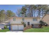 Split-level home with two-car garage, manicured lawn and wood/stone accents at 2044 Teal Cv, Lithonia, GA 30058