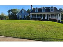 Charming two-story home with a manicured lawn and a welcoming front porch at 2467 Sky Valley Dr, Dacula, GA 30019