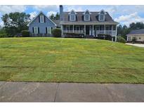 Charming two-story home with a covered front porch and a large front lawn, freshly sodded at 2467 Sky Valley Dr, Dacula, GA 30019