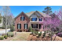 Charming brick two-story home with manicured landscaping and blooming trees in a well-maintained front yard at 8630 Valderama Dr, Duluth, GA 30097