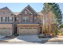 Charming brick townhome showcasing a well-manicured lawn and a two-car garage in a desirable neighborhood at 362 Braemore Mill Dr, Lawrenceville, GA 30044