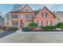 Charming two-story brick home with manicured lawn and mature landscaping providing great curb appeal at 1674 Summersweet Ln, Dacula, GA 30019