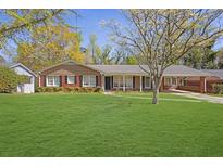 Charming single-story brick home with a well-manicured lawn and mature trees at 2609 Colonial Dr, Atlanta, GA 30337