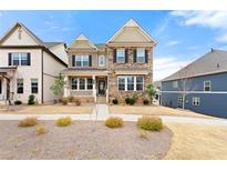 Charming two-story home featuring a stone facade and a well-manicured front lawn at 3534 Diplomat Aly, Scottdale, GA 30079