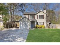 Charming two-story home features a single garage, carport, and a well-maintained lawn at 1124 Brandon Hill Way, Jonesboro, GA 30238