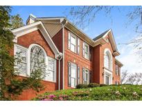 Beautiful brick home with arched windows and lush landscaping at 772 Vinings Estates Se Dr, Mableton, GA 30126