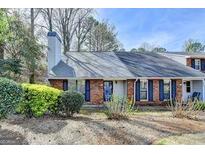 Charming home featuring a brick facade, mature landscaping and a prominent chimney at 1335 Jamestowne Trl, Alpharetta, GA 30009