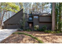 Unique home boasts a modern architectural style with a beautiful yard and mature trees at 4192 Loch Highland Ne Pkwy, Roswell, GA 30075