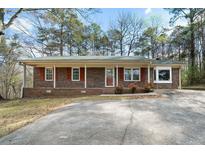 Charming brick home featuring a well-maintained front yard and concrete driveway at 1025 Pace Rd, Hiram, GA 30141