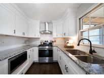 Well-lit kitchen features white cabinets, granite countertops, and stainless steel appliances at 4271 Hiram Lithia Springs Rd, Powder Springs, GA 30127