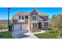 Beautiful brick home featuring a manicured lawn, two-car garage, and welcoming front porch at 5945 Springbox Dr, Suwanee, GA 30024