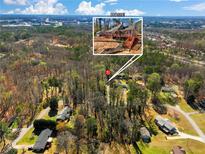 Aerial view of wooded property featuring a charming home with outdoor deck and stairs at 2466 Thrasher Rd, Buford, GA 30519
