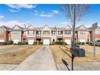 Attractive townhome exteriors with landscaped front yards and attached garages at 156 Haven Oak Way, Lawrenceville, GA 30044