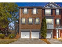Charming townhome featuring a brick facade, double garage, and neat landscaping at 420 Heritage Park Nw Trce # 22, Kennesaw, GA 30144