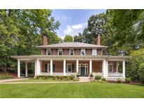 Charming two-story brick home with a full front porch, decorative columns and a lush green lawn at 1308 Fairview Ne Rd, Atlanta, GA 30306