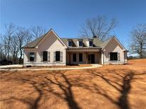 Newly constructed one-story home features painted brick, shutters, and covered front porch with wood columns at 6110 Harvest Way, Cumming, GA 30028