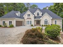 Elegant two-story home with a manicured lawn, attached garage, and covered entryway at 2885 Coles Way, Atlanta, GA 30350