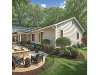 A well-manicured backyard featuring a stone firepit and ample seating with professionally landscaped plantings at 6405 Cherry Tree Ln, Atlanta, GA 30328