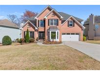 Charming brick home with manicured lawn, two-car garage, and inviting front entrance at 1264 Ridge Vista Nw Ct, Lawrenceville, GA 30043