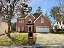 Charming two-story brick home with manicured lawn and attached two car garage at 1496 Brentwood Dr, Marietta, GA 30062