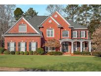Charming two-story red brick home with a well-manicured lawn and beautiful landscaping at 5114 Parkwood Oaks Ln, Mableton, GA 30126