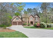 Charming brick home boasts a two-car garage, lush landscaping, and a welcoming driveway at 2702 Long Lake Ne Ter, Roswell, GA 30075
